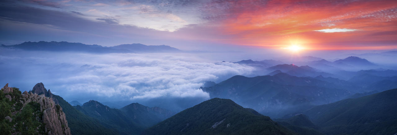 日出下云雾缭绕的山上美景