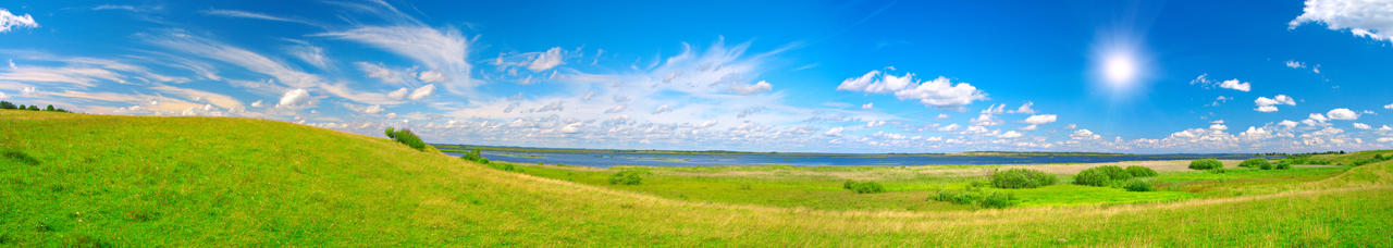 明亮蓝天白云一望无际广阔的草地绿色山谷全景风景图